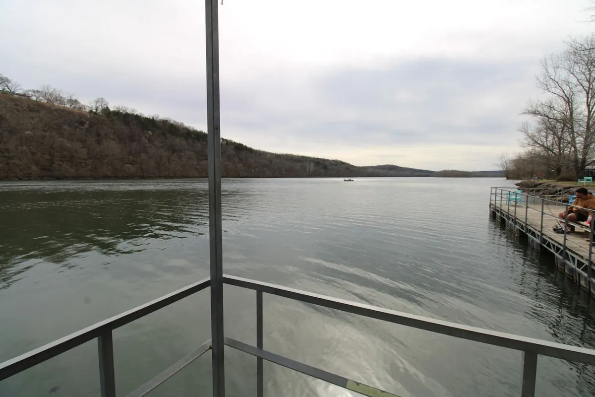 A tranquil dock area overlooking a calm water surface, with distant hills providing a scenic backdrop. The dock is designed for fishing or boating, offering an inviting spot to enjoy nature, launch a boat, or simply relax by the water's edge.